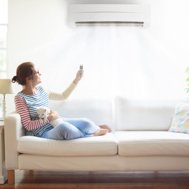 woman with air conditioner remote control.